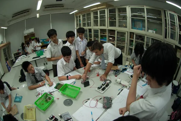Grupa azjatyckich uczniów szkół podstawowych uczy się energii elektrycznej w klasie. — Zdjęcie stockowe