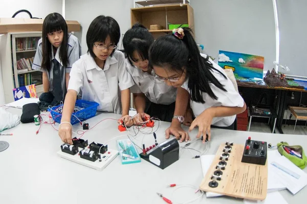 Gruppe asiatischer Grundschüler lernt im Klassenzimmer über Elektrizität. — Stockfoto