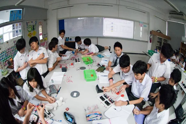 Groep van Aziatische basis studenten leren over elektriciteit in de klas. — Stockfoto