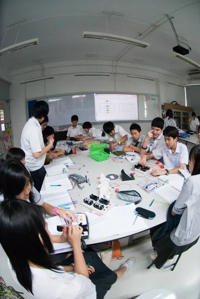 Grupa azjatyckich uczniów szkół podstawowych uczy się energii elektrycznej w klasie. — Zdjęcie stockowe