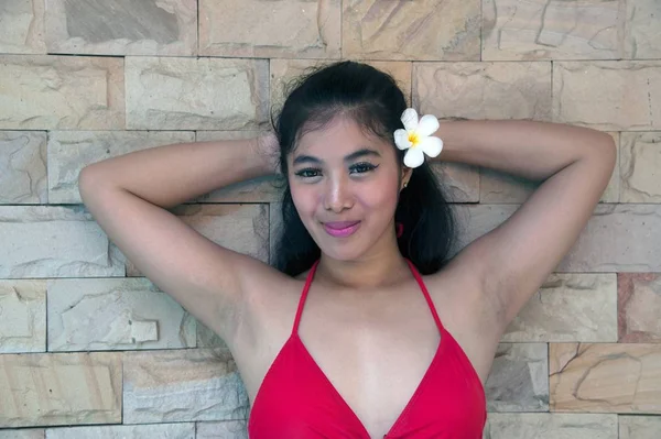 Seksi kırmızı bikini poz ve duvarda ön ayakta güzel Asyalı kadın Portresi. — Stok fotoğraf