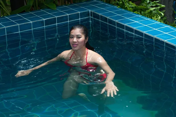 Mujer asiática bonita con bikini rojo nadando en la piscina . — Foto de Stock