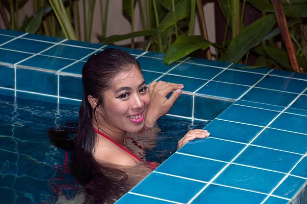 Όμορφη Ασίας γυναίκα φορώντας κόκκινο μπικίνι κολύμπι στην πισίνα. — Φωτογραφία Αρχείου