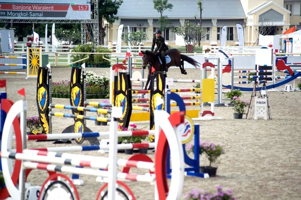 Un joven jinete en un caballo realiza un salto a través de la barrera. Competiciones en el deporte ecuestre . — Foto de Stock