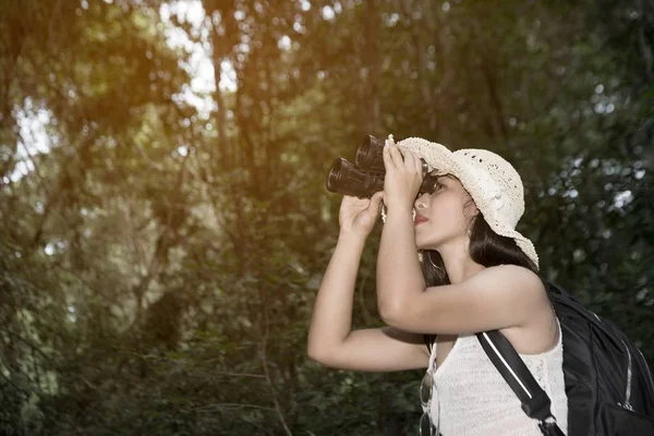 Portrait de jolie femme asiatique regardant à travers les jumelles un bonheur dans la forêt . — Photo