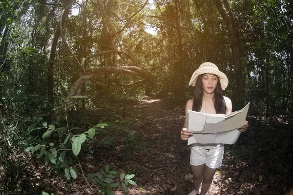 Jolie femme asiatique à la recherche d'une carte dans la forêt . — Photo