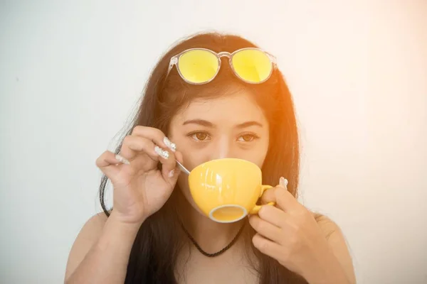 Retrato de mulher asiática de cabelos escuros bebendo café contra no fundo branco . — Fotografia de Stock