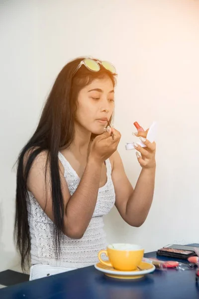 Portretul unei femei asiatice frumoase aplică ruj roșu. Mâna maestrului machiaj, pictura buzelor fetei tinere model de frumusete. Machiaj în proces . — Fotografie, imagine de stoc