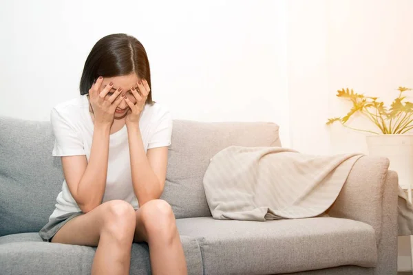 Aziatische vrouw met ernstige migraine hoofdpijn vasthouden van handen te hoofd op witte achtergrond. — Stockfoto