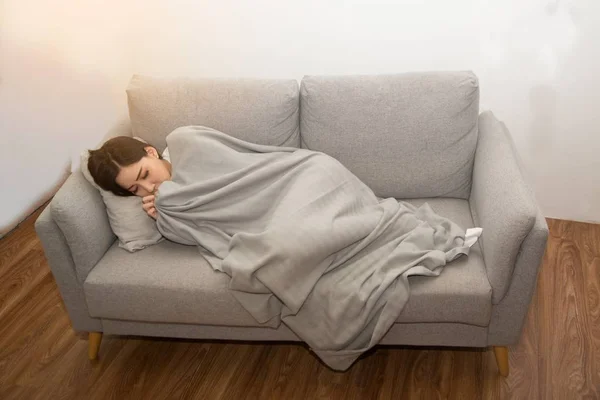 Asiatisk sjuk kvinna täckt med en filt som ligger i sängen med hög feber och en influensa. — Stockfoto