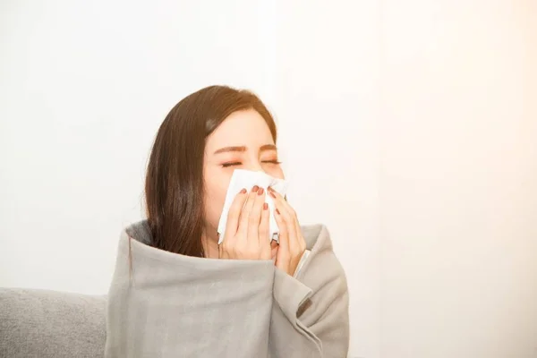 アレルギーに苦しむストレスを持つアジアの女性は、ティッシュペーパーで鼻を閉じます。いつもくしゃみをしているので. — ストック写真
