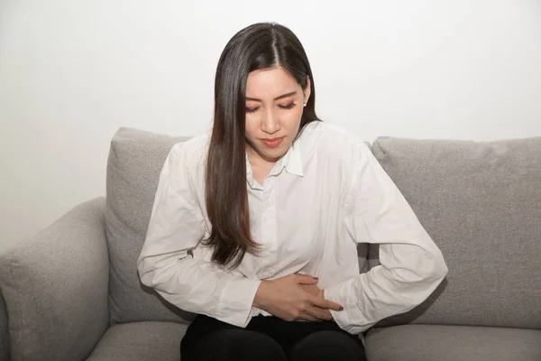 Aziatische vrouw met pijnlijke stomachache, vrouwelijk lijden aan buikpijn. — Stockfoto