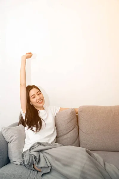 Mujer asiática relajada y descansando respirando fresca en el sofá en casa . —  Fotos de Stock