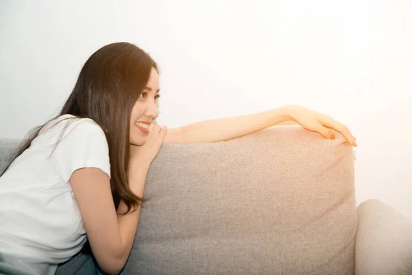 Mulher asiática relaxada e descansando respirando fresco no sofá em casa . — Fotografia de Stock