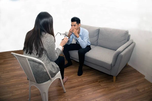 Asian male sitting on couch with Psychologist. — Stock Photo, Image