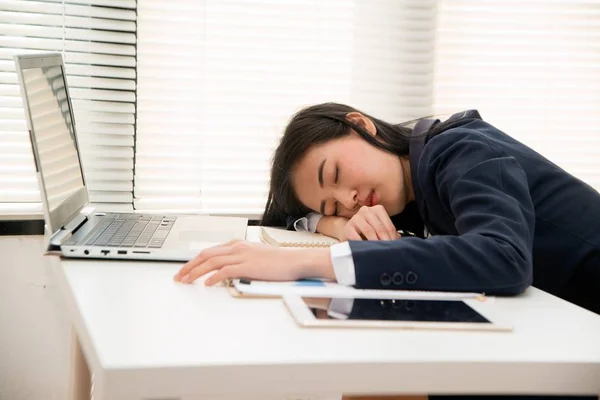 Young Asian business woman lying down on the desk in office because tired overworked. — Stock Photo, Image