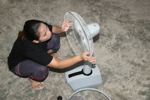 Hushållerska monterar och installerar en elektrisk fläkt efter rengöring. — Stockfoto