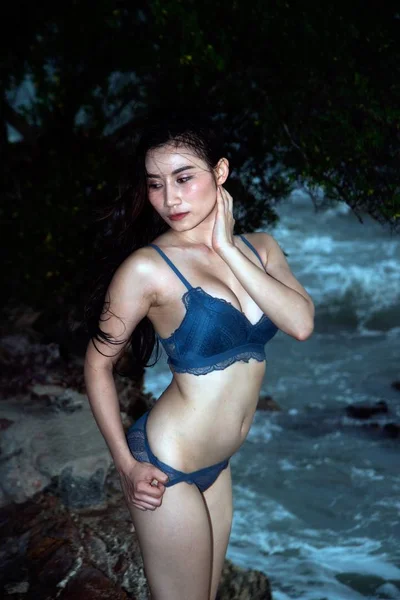 Досить Азіатська жінка в блакитному бікіні постановки на пляжі з кумедними. — стокове фото