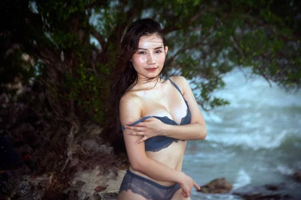 Hübsche asiatische Frau im blauen Bikini posiert am Strand mit Spaß. — Stockfoto