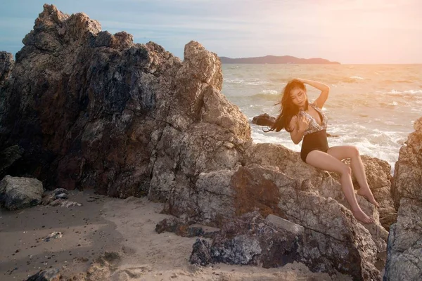 Mujer asiática bonita en traje de baño posando en la piedra de la playa . —  Fotos de Stock