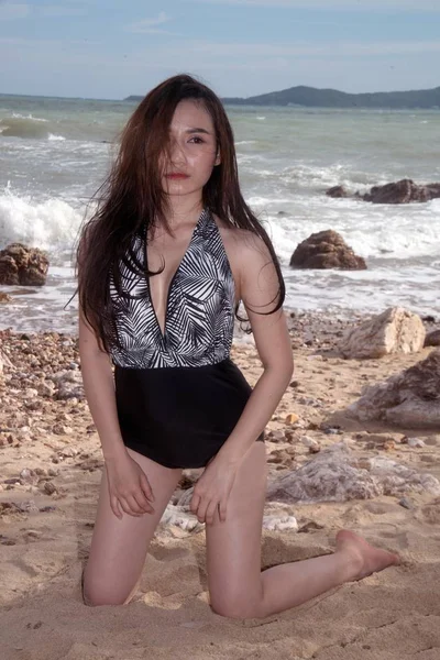 Plaj taş üzerinde poz mayo Pretty Asyalı kadın.