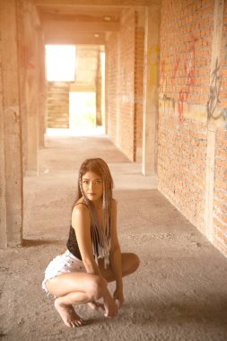 Güzel bir Asyalı kadın inşaat halindeki bir binada poz veriyor.. 