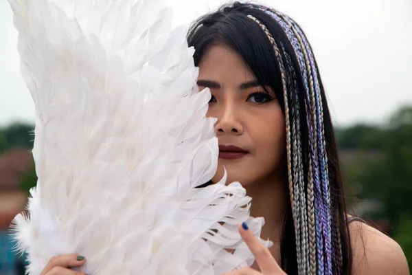 Porträtt en vacker asiatisk kvinna har en fågel vingar stående pose. — Stockfoto