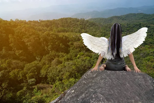 Asiatico bellezza con uccello ali a il indietro, seduta su il rocce . — Foto Stock