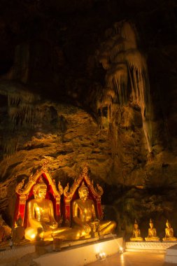Altın Buda Tılsımı grubu Khao Luang Mağarası 'ndaki kayaya kondu. Phetchaburi Eyaleti Merkez Tayland. 
