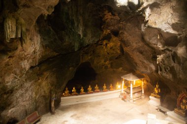 Altın Buda Tılsımı grubu Khao Luang Mağarası 'ndaki kayaya kondu. Phetchaburi Eyaleti Merkez Tayland. 