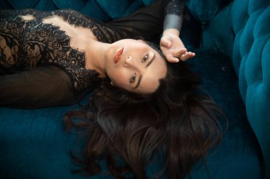 Şehvetli seksi elbiseler Asyalı kadınlar mavi koltukta uzanır..