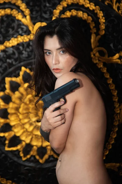 Retrato bastante asiática sensualidad modelo pose celebración pistola en estudio disparo . — Foto de Stock