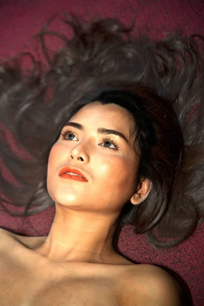 Sensual nude Asian women sensuality lying on the red floor. — Stock Photo, Image