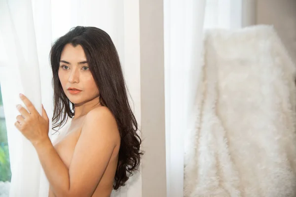 A tökéletes egy gyönyörű ázsiai nő. És elöl áll a fehér függöny, a fény átjön az ablakon.. — Stock Fotó