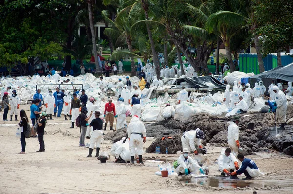 타이어 확인되지 노동자들 봉사자들 해변에 비닐봉지에 원유로 모래를 삽으로 퍼내고 — 스톡 사진