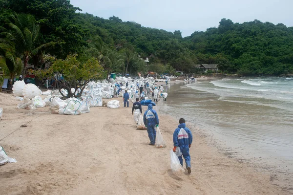 RAYONG, THAILAND-FEBRUARY 8. 2013: Tayland 'da Khao Laem Ya-Mo Ko samet Ulusal Parkı' ndaki Prew sahilindeki büyük bir plastik torba içinde ham petrolle kumu küreyen tanımlanamayan işçiler ve gönüllüler.