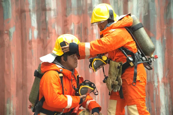 二人のアジアの消防士の肖像画は 建物の前にオレンジ色の防火制服のマスクとヘルメットを着ている — ストック写真