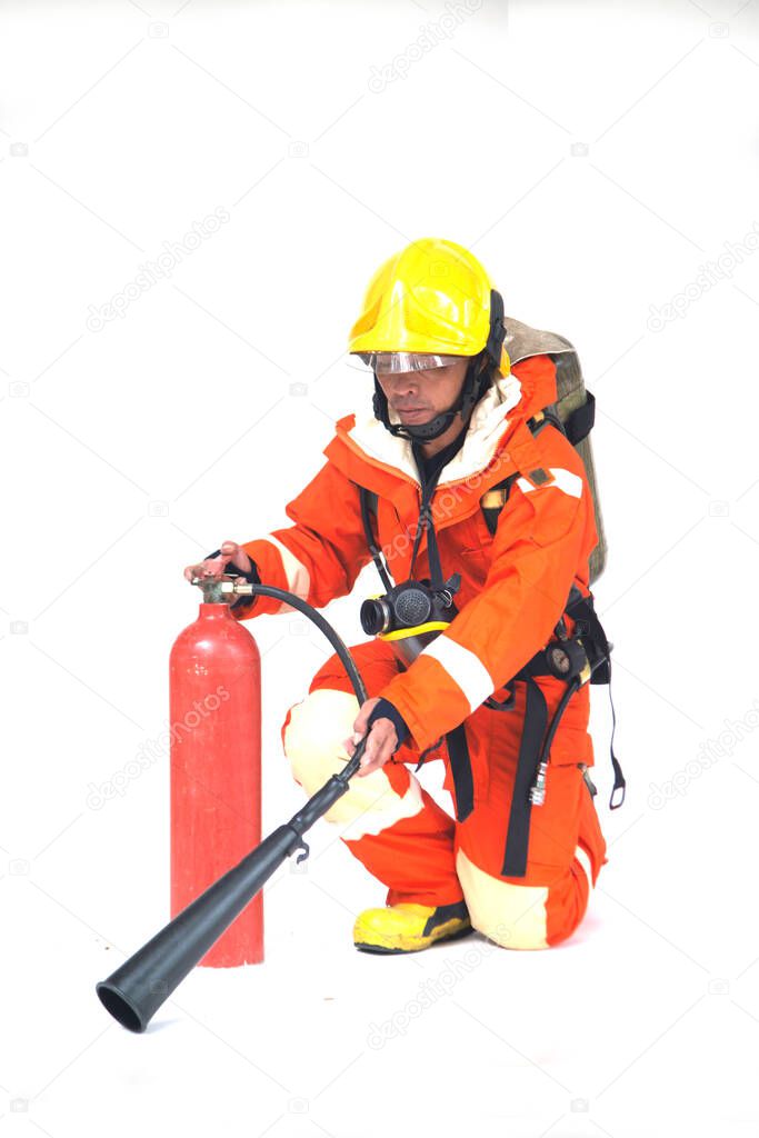 A portrait of Asian male firefighter in orange protective uniform, mask and helmet with fire extinguisher sitting on white background.