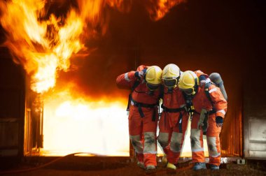 İtfaiyeciler yanan binadan çıkarak işçilere yardım ediyor..