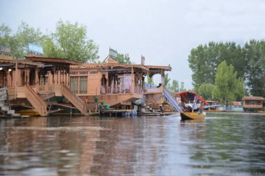 SRINAGAR, INDIA-MAY10, 2019: House Boats Dalmi Gölü 'nün kıyısında. Mimarilerinde eşsizdirler, güzel oyulmuş ve lüks bir malikanede yaşamak gibi çeşitli konforlarla donatılmışlardır. Yüzen evler gibi yaratılmışlardır..
