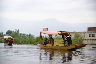 SRINAGAR, INDIA - 10 Mayıs 2019: Shikaras, Dal Gölü sisteminde yüzen ev ve popüler bir turist aktivitesi için ulaşım sağlayan ahşap kayıklardır.