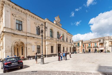 Palazzolo Acreide / Syracuse Sicilya / İtalya - Ekim 04: 2019: İki jandarma, Palazzolo Acreide katedralinin önündeki basamaklarda konuştu ve bazı turistlere bilgi verdi