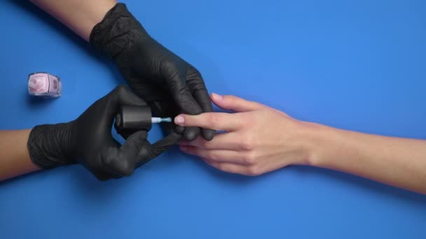 Manicurista pinta las uñas de los clientes con esmalte de uñas protector transparente — Vídeos de Stock