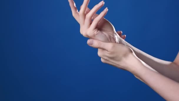 Close-up shot van de vrouwen handen zijn het aanbrengen van handen crème — Stockvideo