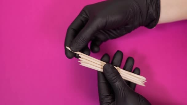Maniküre behandelt Nagelhaut mit Holzstäbchen im Schönheitssalon Stockvideo