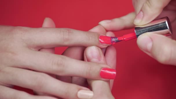 Маникюрша красит ногти клиентов бежевым лаком для ногтей — стоковое видео