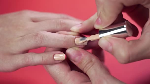 Manicura pinta las uñas de los clientes con esmalte de uñas de tinte beige — Vídeos de Stock