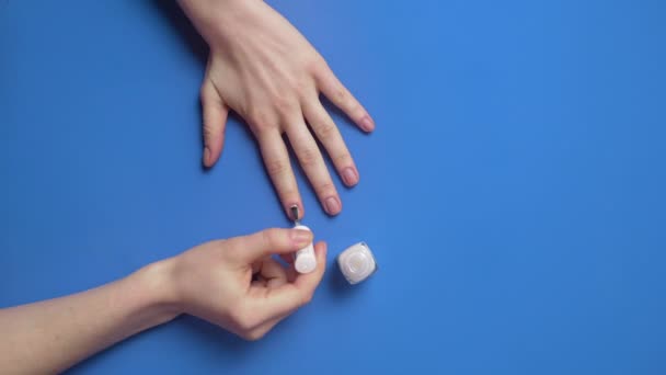 Γυναίκα ζωγραφίζει τα νύχια της με διαφανές προστατευτικό βερνίκι νυχιών — Αρχείο Βίντεο