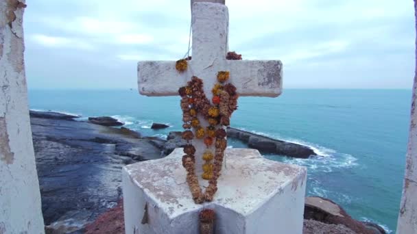 Croce bianca con fiori sulla collina sulla costa dell'oceano — Video Stock