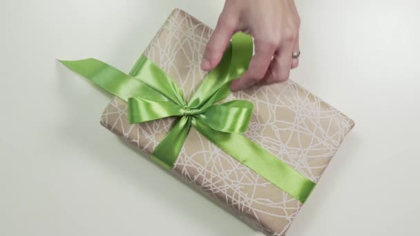 Nahaufnahme der Frauenhände, die eine Verbeugung auf dem Geschenkkarton binden — Stockvideo
